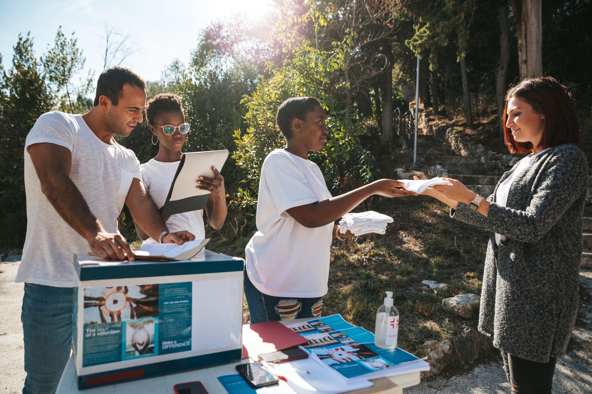 Multicultural group of young volunteers distribute flyers and leaflets in the street