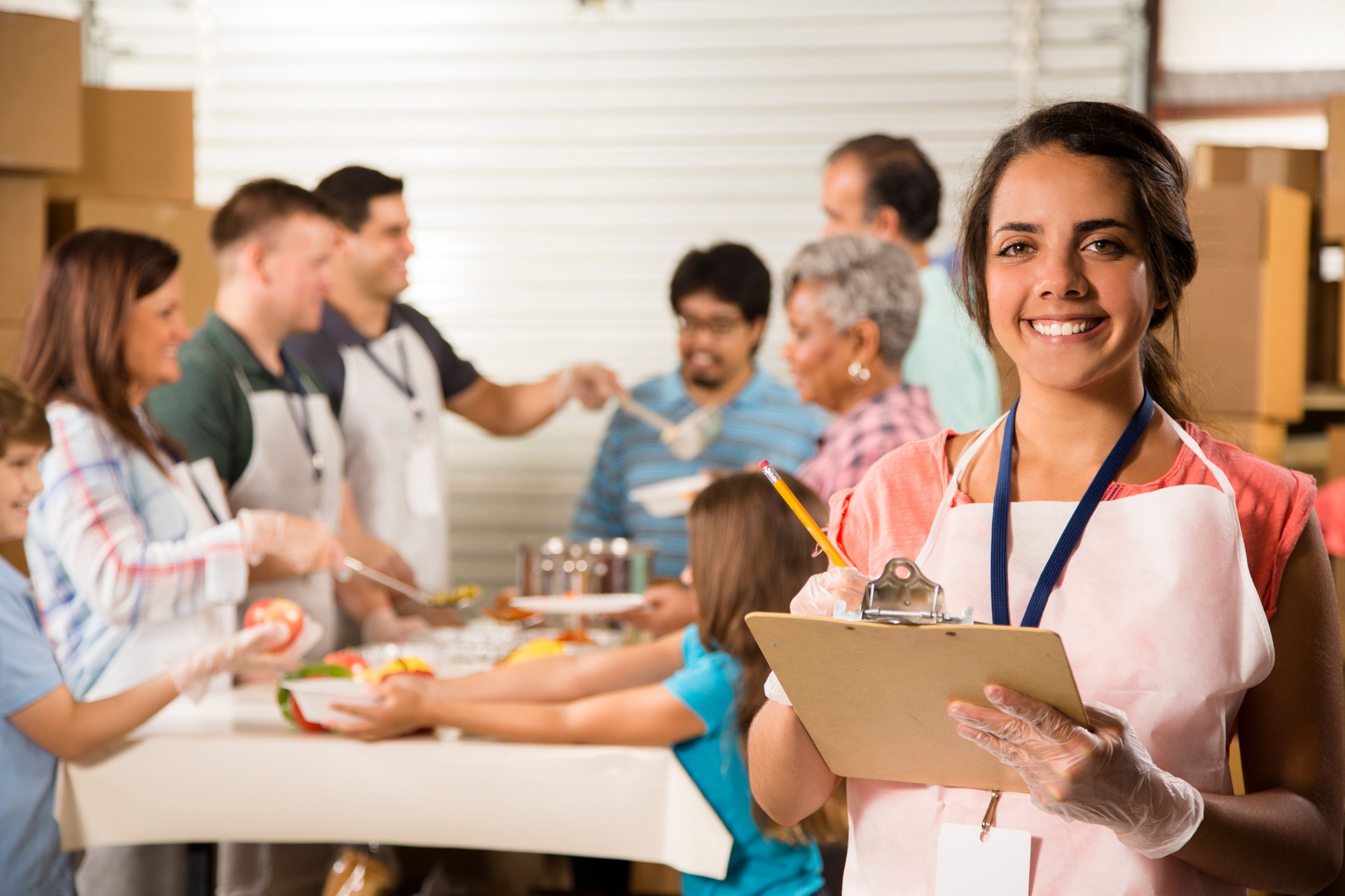 Group of volunteers serve food at community soup kitchen. Charity.